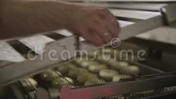 在工厂制作油炸圈饼的过程油炸面团糖果或甜点食品的概念把视频的预览图