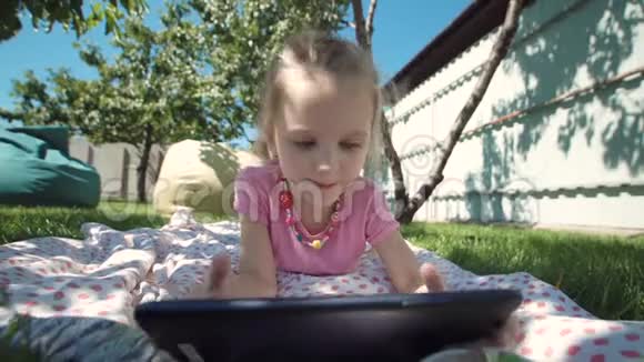 在草坪上摆着平板电脑的迷人女孩视频的预览图