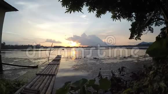 日落时分竹筏漂浮在被污染的湖面上视频的预览图