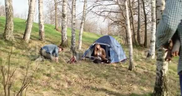 朋友带木头的时候人点着火的地方真正的朋友人们户外露营帐篷度假秋游视频的预览图