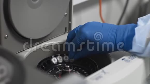 实验室技术人员用生物材料取样管装载医用离心机视频的预览图
