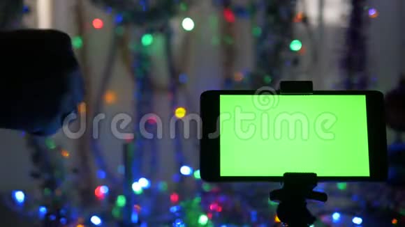智能手机绿色屏幕在新年背景他点燃了节日的烟火视频的预览图