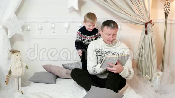 冬天父母和孩子在家里玩男孩和爸爸玩得很开心爸爸和儿子家庭幸福视频的预览图