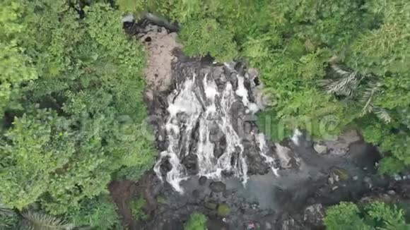 水流入河流的瀑布在绿色热带丛林中鸟瞰4K视频的预览图