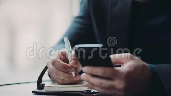 一个严肃时尚的商人用他的手机做笔记当老板忙碌的生活方式成功的生活男性视频的预览图