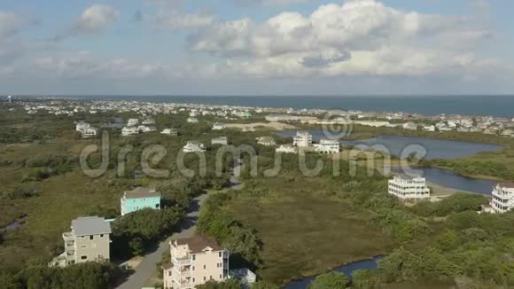 鸟瞰豪华住宅飞在城镇和海滩之上4k视频的预览图