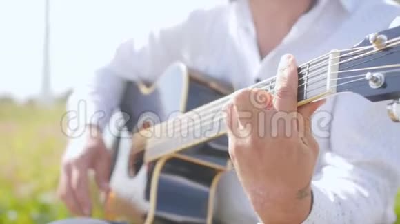 人弹吉他唱自然吉他手触摸吉他弦近距离射击视频的预览图