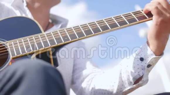 人弹吉他唱自然吉他手触摸吉他弦近距离射击视频的预览图