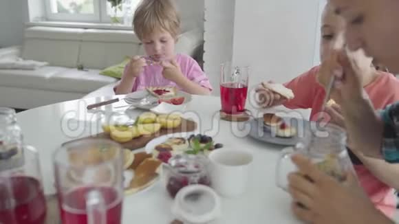 幸福的年轻家庭在厨房吃早餐营养餐视频的预览图
