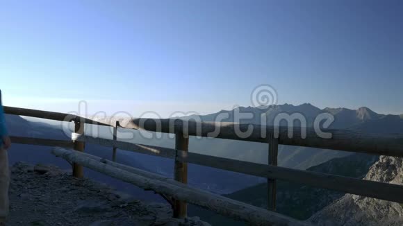 一对夫妇步行到木制阳台看阿尔卑斯山日出时的山景视频的预览图