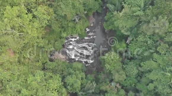 水流入河流的瀑布在绿色热带丛林中鸟瞰4K视频的预览图
