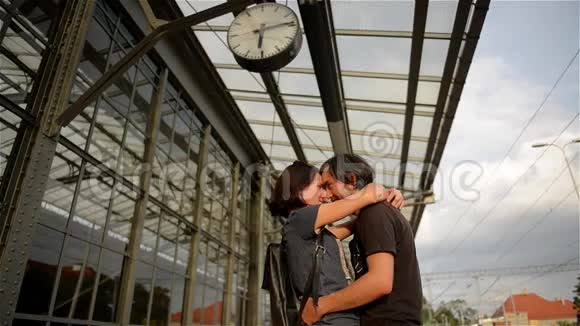 快乐的一对拥抱在火车站站台上在火车站告别年轻的女孩和男人在谈论视频的预览图