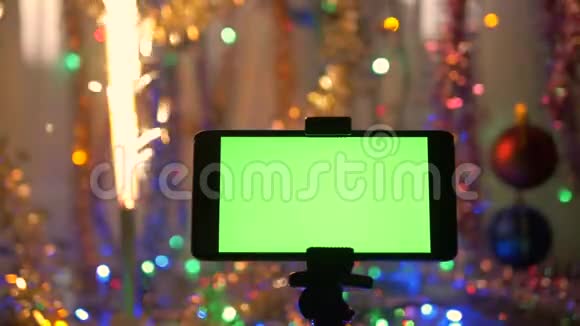 智能手机绿色屏幕在新年背景节日的烟火正在燃烧视频的预览图