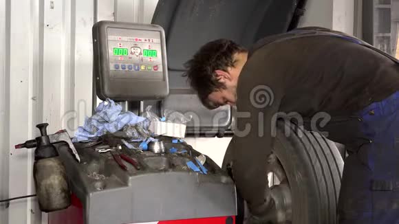 在车库使用现代车轮平衡工具的技术员视频的预览图