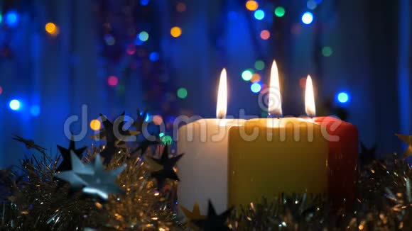 特写新年蜡烛和圣诞装饰品有彩色灯光的模糊背景视频的预览图