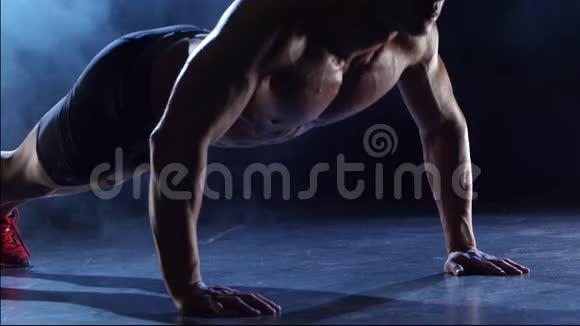 举重运动员正在锻炼从地板上握手黑烟背景剪影视频的预览图