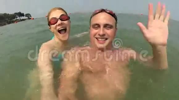 快乐的年轻夫妇在海里玩得很开心准备拍摄潜水暑假操作摄像机视频的预览图