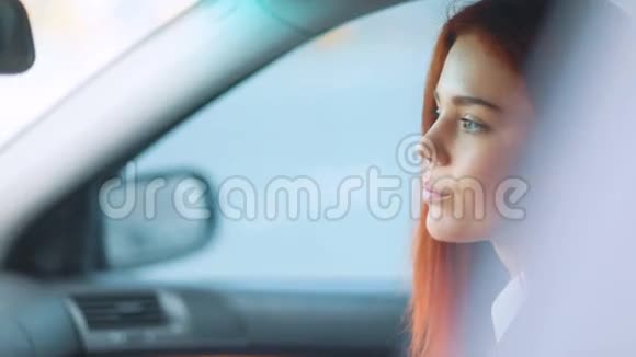 一个穿着浅棕色夹克的红发女孩坐在车里神情焦急视频的预览图