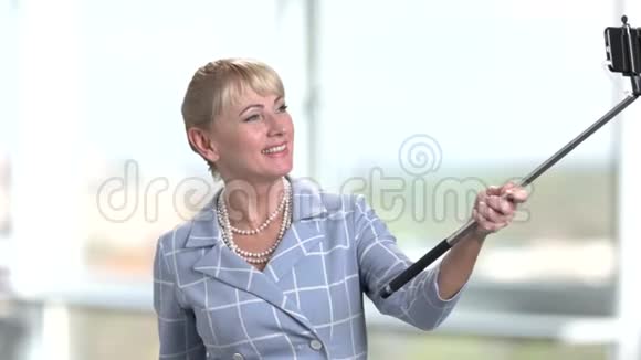 成熟的商业女性使用自拍棒视频的预览图