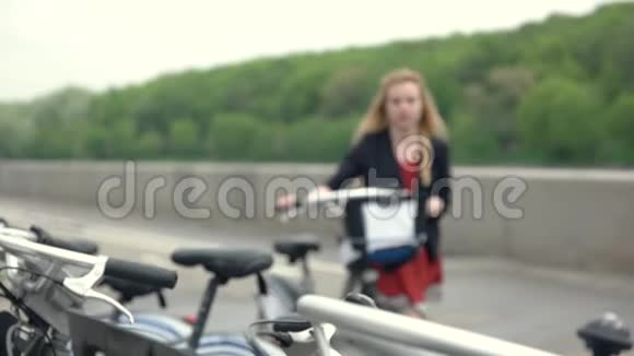 年轻的金发女人骑自行车停自行车的女孩视频的预览图