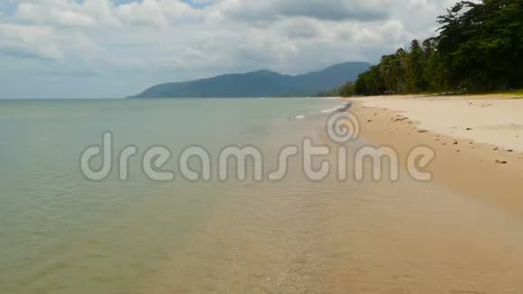 白色的沙质海岸和平静的蓝海田园诗般的热带天堂异国情调的岛屿景观绿色的树木安静的视频的预览图