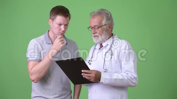 高级胡子男医生绿色背景下咨询男病人视频的预览图