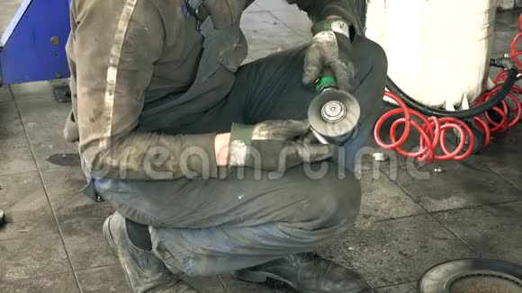 汽车机械师在提升车附近用电动磨床工具打磨生锈螺栓视频的预览图