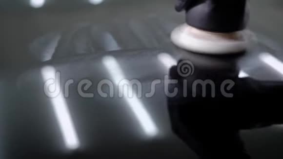 近距离拍摄一名男子用特殊工具打蜡汽车引擎盖视频的预览图