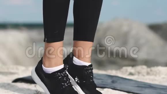 穿着黑色运动服的运动型黑发女孩在一个蓝水白垩沙场上训练打嗝视频的预览图