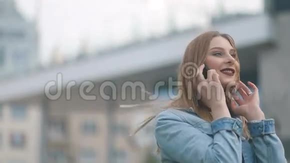 漂亮迷人的模特金发女孩和深红色的嘴唇在蓝色牛仔球场和严格的模糊Stadicam视频的预览图