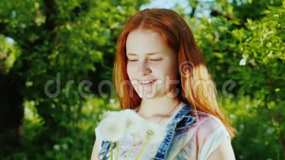一个红头发的女孩玩得很开心玩蒲公英花视频的预览图