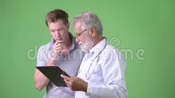 高级胡子男医生绿色背景下咨询男病人视频的预览图