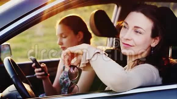 一个年轻的女人和她十几岁的女儿在一起他们坐在车里我妈妈钦佩大自然我的视频的预览图