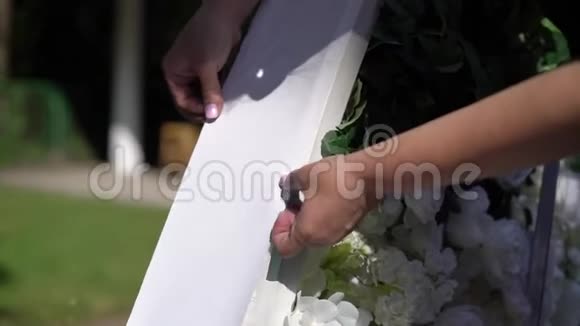 结婚结婚典礼拱门拱门装饰着白花站在树林里在婚礼区视频的预览图