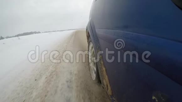 脏雪从汽车的车轮下飞了出来汽车侧面的慢动作视频视频的预览图