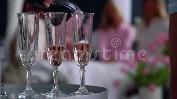一个漂亮女孩的特写镜头为那些在后台玩得开心的女朋友装上了香槟酒杯视频的预览图