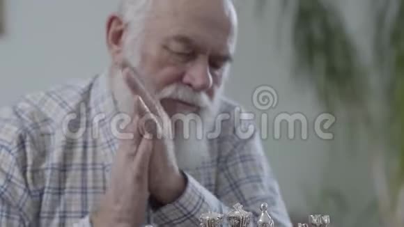 留着胡子的老成熟男人的画像想着哪一个棋子要出手两个人坐着下棋视频的预览图