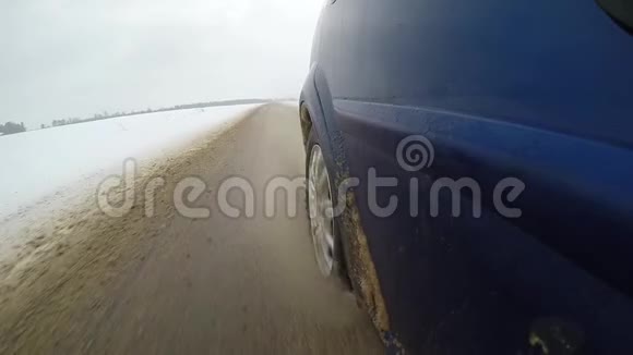 脏雪从汽车的车轮下飞了出来汽车侧的慢动作视频视图开着一辆车视频的预览图