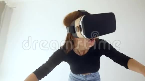 一个戴着虚拟现实耳机的女孩伸出双手视频的预览图