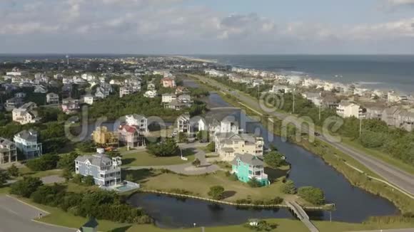 鸟瞰豪华住宅飞在城镇和海滩之上4k视频的预览图