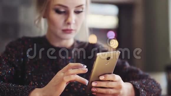 坐在咖啡馆里用手机自娱自乐的迷人年轻女子上网成为视频的预览图