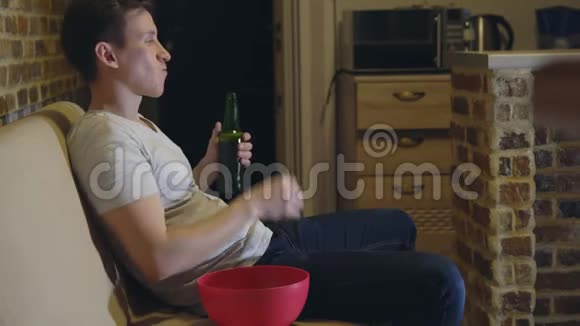 男人喝啤酒喝薯条看足球视频的预览图
