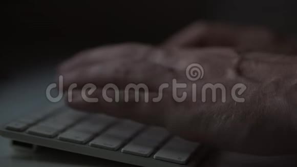 一个男人在黑暗的房间里用电脑键盘打字视频的预览图