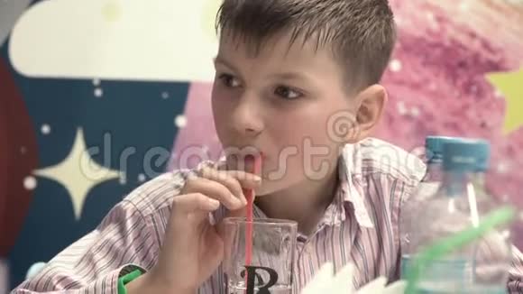 男孩在管子的帮助下喝果汁视频的预览图