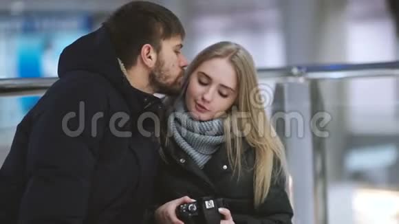 年轻有魅力的情侣在购物中心用相机观看照片视频的预览图