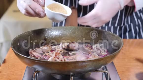 在餐厅的一个热煎锅上加入肝片的厨师烹饪弗拉姆贝式菜肴手戴手套视频的预览图