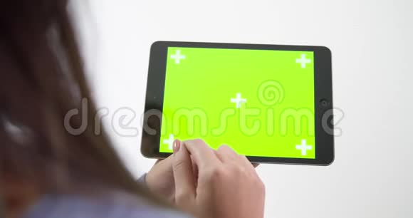 一张年轻女子用绿色屏幕的平板电脑拍摄的照片视频的预览图