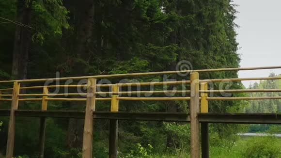 一对游客小心翼翼地走过一座横跨山河的桥视频的预览图
