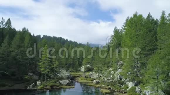 在阳光明媚的夏天在蓝色的阿尔卑斯湖上空的空中倒转在云层笼罩下露出山林谷欧洲阿尔卑斯山户外视频的预览图