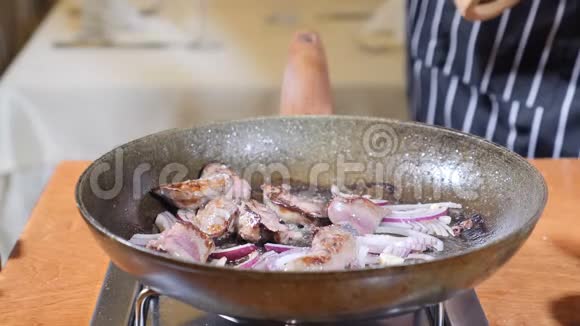 在餐厅的一个热煎锅上加入肝片的厨师烹饪弗拉姆贝式菜肴手套加手视频的预览图